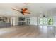Spacious living room with hardwood floors, ceiling fans, and an open layout flowing into the kitchen at 3225 Rosery Ne Rd, Largo, FL 33771