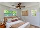 This main bedroom features wood floors, a ceiling fan, two windows and has neutral paint at 3225 Rosery Ne Rd, Largo, FL 33771