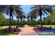 Scenic park pathway lined with palm trees, benches, and landscaping at 3225 Rosery Ne Rd, Largo, FL 33771