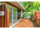 Private patio featuring tile flooring, tropical landscaping and sliding glass door access to the interior at 3225 Rosery Ne Rd, Largo, FL 33771