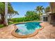 Beautiful kidney-shaped pool surrounded by mature landscaping and a tiled patio at 3225 Rosery Ne Rd, Largo, FL 33771