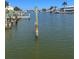 View of canal with docks, boat lifts, calm water, and tropical landscaping at 326 Windrush Blvd # 103, Indian Rocks Beach, FL 33785