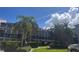 A condo building with palm trees and beautiful landscaping in front on a sunny day at 326 Windrush Blvd # 103, Indian Rocks Beach, FL 33785