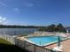 Community pool with tables, chairs, chaise lounges, and landscaping overlooking the canal at 326 Windrush Blvd # 103, Indian Rocks Beach, FL 33785