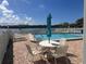 Community pool overlooking the canal, with lounge chairs, tables, and lush landscaping at 326 Windrush Blvd # 103, Indian Rocks Beach, FL 33785