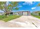 Front exterior view of home featuring a mature tree, grey paint, and a front-facing garage at 4016 Grayton Dr, New Port Richey, FL 34652