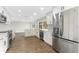 Bright kitchen features white cabinets, stainless steel appliances, countertops, and wood flooring at 4016 Grayton Dr, New Port Richey, FL 34652