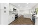 Bright kitchen features white cabinets, stainless steel appliances, countertops, and wood flooring at 4016 Grayton Dr, New Port Richey, FL 34652