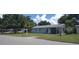 Charming single-story home with a well-maintained lawn and mature trees under a sunny, partly cloudy sky at 4105 W Tyson Ave, Tampa, FL 33611