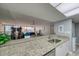 Bright kitchen features granite countertops, stainless steel sink and a view into the living space at 440 S Gulfview Blvd # 701, Clearwater Beach, FL 33767