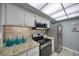 Bright kitchen featuring granite counters, stainless steel appliances, and a stylish tiled backsplash at 440 S Gulfview Blvd # 701, Clearwater Beach, FL 33767