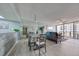 Inviting living and dining area with stylish furniture, a mirrored wall, and a ceiling fan; beach views through the windows at 440 S Gulfview Blvd # 701, Clearwater Beach, FL 33767