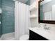 This bathroom features teal blue tile in the shower and dark wood vanity at 4505 S Clark Ave, Tampa, FL 33611