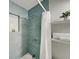 Stylish bathroom featuring teal tile in the shower, white shelves, and plant decor at 4505 S Clark Ave, Tampa, FL 33611
