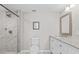 Bright bathroom featuring a shower and vanity with white cabinets and a granite countertop at 4718 W Oklahoma Ave, Tampa, FL 33616