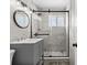 Bathroom featuring a sink vanity and a walk-in shower with a dark-framed glass door at 4718 W Oklahoma Ave, Tampa, FL 33616