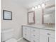 Bright bathroom featuring a dual vanity with white cabinets and granite countertops at 4718 W Oklahoma Ave, Tampa, FL 33616