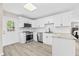 Modern white kitchen with stainless steel appliances, granite countertops, and stylish tile backsplash at 4718 W Oklahoma Ave, Tampa, FL 33616