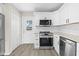 Updated kitchen with stainless steel appliances, light countertops, and stylish backsplash at 4718 W Oklahoma Ave, Tampa, FL 33616