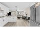 Bright and modern living area featuring an open floor plan into kitchen with white cabinets at 4718 W Oklahoma Ave, Tampa, FL 33616