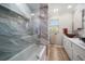 Elegant bathroom with marble-like tile, a glass-enclosed shower, and double vessel sinks at 4754 Overlook Ne Dr, St Petersburg, FL 33703
