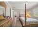 Bright bedroom featuring a four-poster bed, wood-look flooring, and a charming dresser at 4754 Overlook Ne Dr, St Petersburg, FL 33703