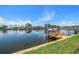 Waterfront home with a wooden dock and boat lift on a sunny day at 4754 Overlook Ne Dr, St Petersburg, FL 33703