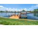 Waterfront home featuring a private wooden dock with boat lift and chairs on a bright sunny day at 4754 Overlook Ne Dr, St Petersburg, FL 33703