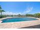 Waterfront home's in-ground pool and brick paver deck overlook the canal on a sunny day at 4754 Overlook Ne Dr, St Petersburg, FL 33703