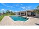 Beautiful in-ground pool with brick paver deck and covered patio of waterfront home on a bright sunny day at 4754 Overlook Ne Dr, St Petersburg, FL 33703