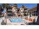 Attractive community pool surrounded by a white fence, palm trees and comfortable seating areas at 5000 Culbreath Key Way # 1-220, Tampa, FL 33611