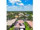 An aerial view shows the neighborhood with lake and roofs, some with solar panels at 5103 Shady Stone Pl, Wimauma, FL 33598