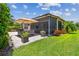 Lush backyard with patio, dining set, grill, landscaping, screen and inviting green lawn creating outdoor retreat at 5103 Shady Stone Pl, Wimauma, FL 33598