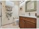 Bright bathroom featuring a decorative mirror, wood vanity, and neutral toned walls and floors at 5103 Shady Stone Pl, Wimauma, FL 33598