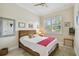 Comfortable bedroom with wooden framed bed, tiled floor, and a large window with shutters for natural light at 5103 Shady Stone Pl, Wimauma, FL 33598