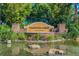 Entrance sign for Valencia Lakes, a GL Homes community, set amidst lush greenery and a serene pond at 5103 Shady Stone Pl, Wimauma, FL 33598