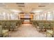 Large event space with rows of chairs facing a stage, chandeliers, and natural light from the curtains at 5103 Shady Stone Pl, Wimauma, FL 33598