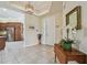 Inviting entryway featuring neutral tile, a decorative mirror, and a view into the adjacent kitchen at 5103 Shady Stone Pl, Wimauma, FL 33598