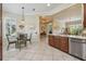 Well-lit kitchen and breakfast nook featuring wood cabinetry, tiled floors, and modern appliances at 5103 Shady Stone Pl, Wimauma, FL 33598