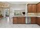 Well-designed kitchen featuring wood cabinetry, stainless steel appliances, and a view into the living area at 5103 Shady Stone Pl, Wimauma, FL 33598