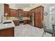 Modern kitchen featuring stainless steel appliances, wood cabinets, tiled floors, and a cozy breakfast nook at 5103 Shady Stone Pl, Wimauma, FL 33598