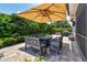 Relaxing outdoor patio area with an umbrella-covered dining set and lovely landscaping creating a private oasis at 5103 Shady Stone Pl, Wimauma, FL 33598