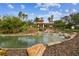 Community center with a pond, palm trees, waterfall, and tropical landscaping at 5103 Shady Stone Pl, Wimauma, FL 33598