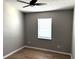 A bedroom featuring a ceiling fan, gray walls, hardwood floors, and a bright window at 5423 Sweetwater Terrace Cir, Tampa, FL 33634
