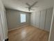 A bedroom featuring hardwood floors, gray walls, a ceiling fan, and a bright window at 5423 Sweetwater Terrace Cir, Tampa, FL 33634