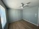 Bedroom featuring custom-built paneling, a ceiling fan, hardwood floors, and a bright window at 5423 Sweetwater Terrace Cir, Tampa, FL 33634