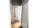 Hallway with neutral walls, wood-look flooring, and white doors, creating a bright and airy atmosphere at 5423 Sweetwater Terrace Cir, Tampa, FL 33634