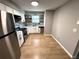 Modern kitchen featuring stainless steel appliances, granite countertops, white cabinets, and floating shelves at 5423 Sweetwater Terrace Cir, Tampa, FL 33634