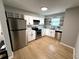 Bright kitchen featuring modern appliances, white cabinetry, granite countertops, and floating shelves at 5423 Sweetwater Terrace Cir, Tampa, FL 33634