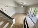 Living room view from staircase featuring balcony access and vaulted ceilings at 5423 Sweetwater Terrace Cir, Tampa, FL 33634
